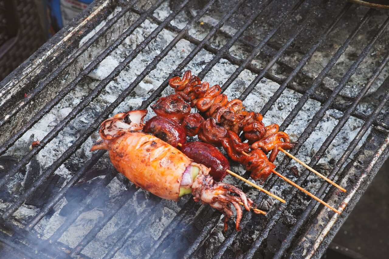 Squid skewers charring on the grill